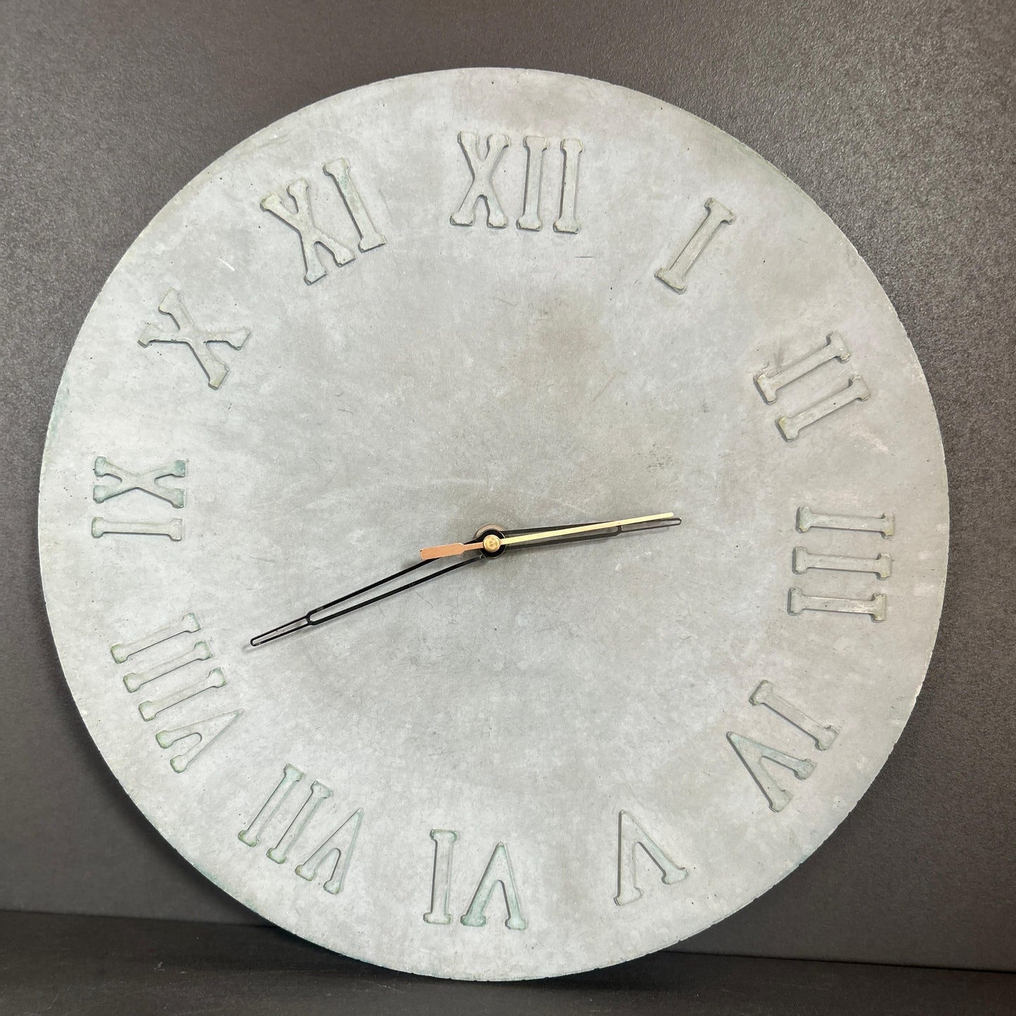 Concrete wall clock with Roman numeral