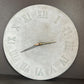 Concrete wall clock with Roman numerals on a gray background