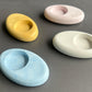 Four concrete candle holders in pastel colors 
